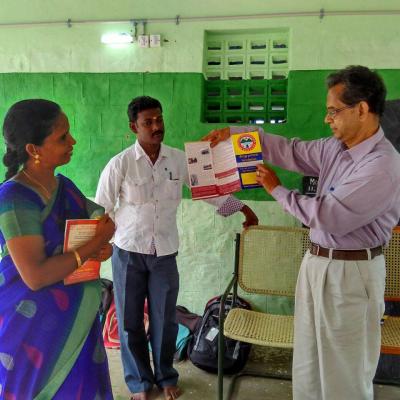 Dpf Managing Trustee Displaying The Brochure Of Dpf To Explain Its Activities