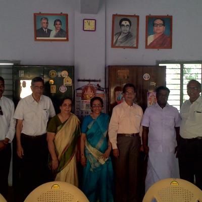 Guests Standing Below The Photos Of The Founders Of Balar Illam